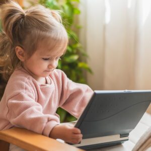 Toddler using tablet on armchair