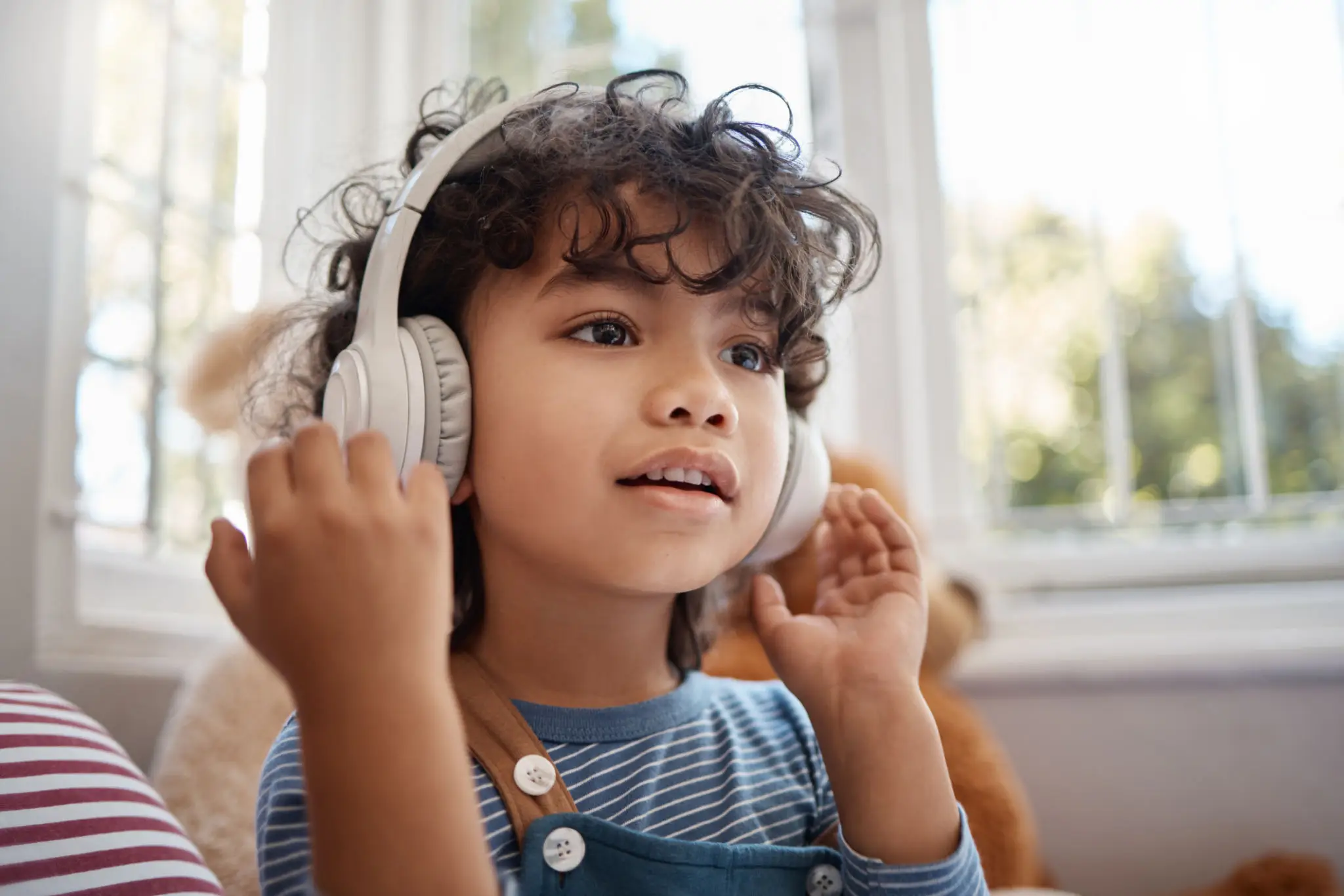 Child wearing headphones listening at home