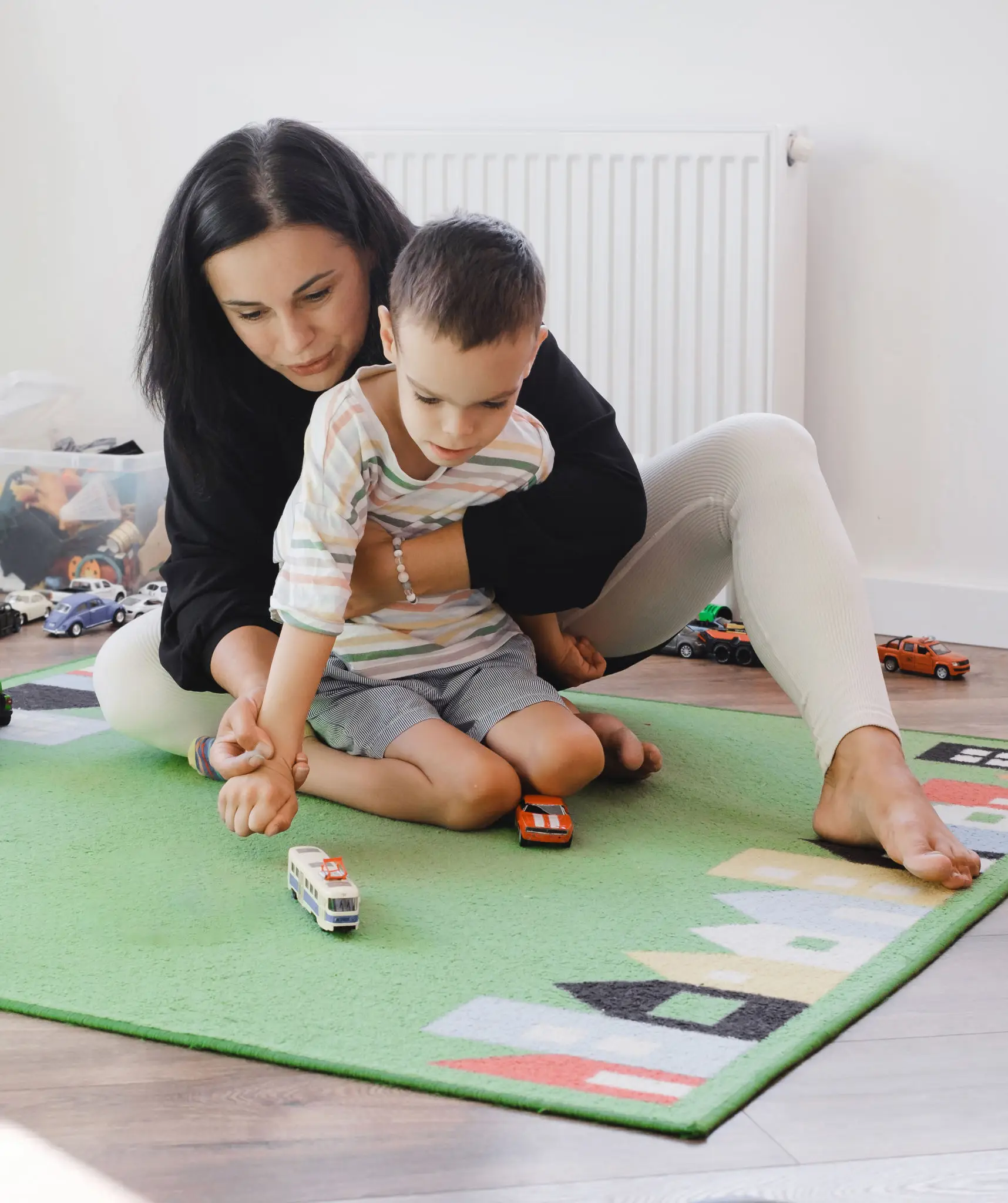 Mother and child playing with toy cars