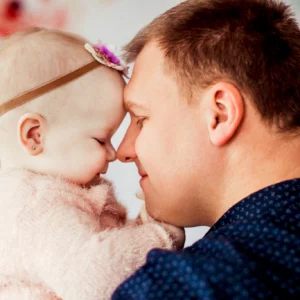 Father and baby girl sharing tender forehead touch