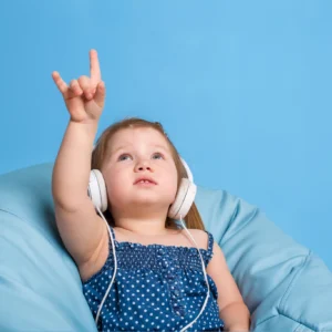 Girl on blue beanbag wearing headphones pointing upward