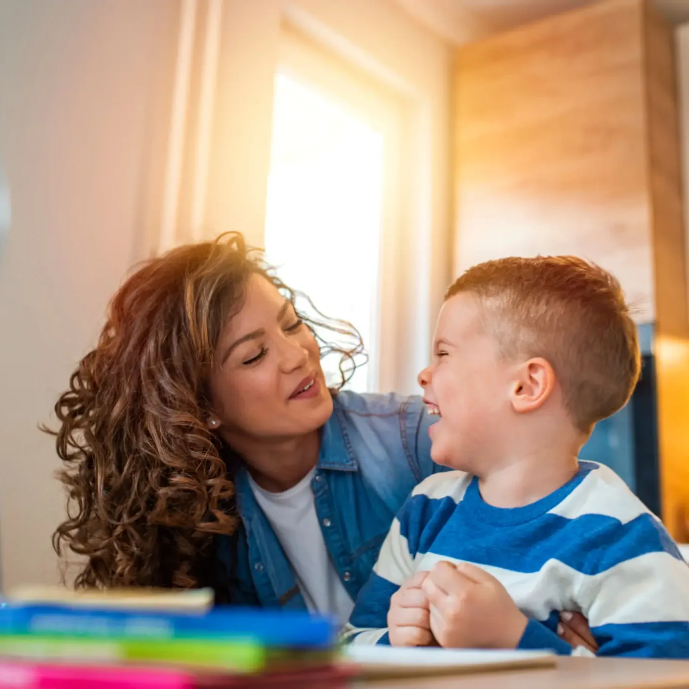 Mother helping son with homework, smiling